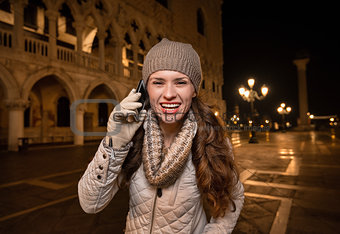 Smiling woman tourist talking cell phone on Piazza San Marco