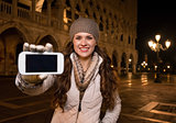 Happy woman tourist showing smartphone on St. Mark's Square