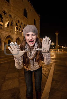 Cheerful woman shouting through megaphone shaped hands in Venice