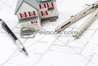 Model Home, Pencil and Compass Resting On House Plans