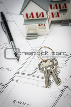 Model Home, Pencil and Keys Resting On House Plans