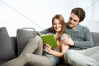 Young  couple with book in apartment interior