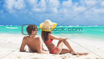 happy young couple lying on a tropical beach in Barbados