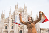 Happy woman with shopping bags rejoicing in the front of Duomo
