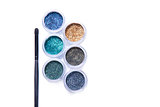 Makeup brush and colorful glitters in transparent jars 