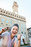 Woman tourist with photo camera showing thumbs up, Florence