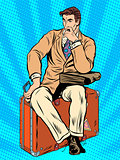 Man traveler sitting on a suitcase