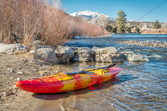 whitewater kayak on river shore