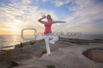 Woman balance drinking wqter during exercise