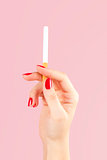 Female hand holding cigarette.