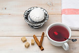 Cup of red tea. Cane sugar and cinnamon sticks with sweet dessert