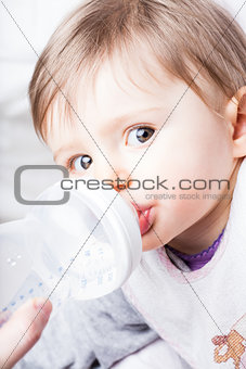 baby eating from her baby bottle
