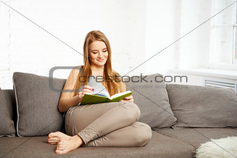 Young Woman Reading a Book at home