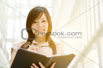 Young Asian female executive with diary