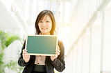 Young Asian business woman holding blank board