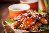 Hot chicken wings cooked with honey and soy,  topped with sesame