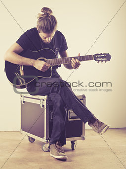 Young man sitting and playing guitar