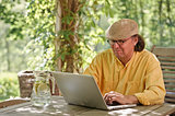 senior man outdoors with laptop