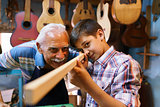Old Man Luter Teaching Grandson Boy Chiseling Wood