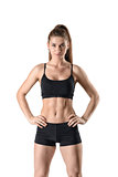 Beautiful sporty woman demonstrating press stomach and looks directly at the camera.