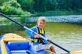 Happy boy kayaking on the river
