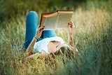 Beautiful girl reading a book on the Nature