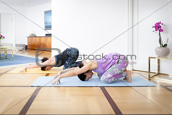 two women doing yoga at home Balasana variation