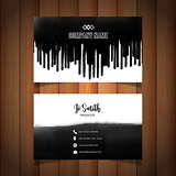 Business card with black paint drips