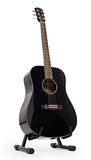 Black acoustic guitar on stand, isolated