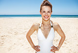 Portrait of smiling woman in white swimsuit at sandy beach