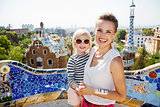 Smiling mother and baby spending fun time at Park Guell