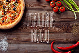 Italian pizza with tomatoes on a wooden table, top view, close-up