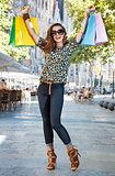 Happy woman with shopping bags rejoicing near Sagrada Familia