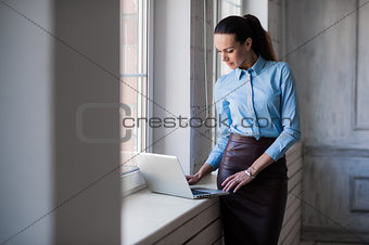 Young successful happy smiling business woman on laptop