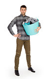 Full length portrait of a young man holding a laundry basket