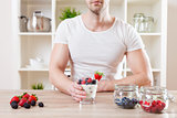 Closeup on man with delicious yoghurt with fresh berries