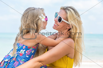 Cute girl and beautiful mother on the beach