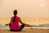woman in sportswear doing yoga at sunset