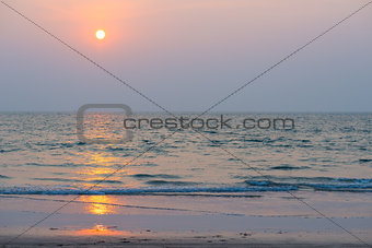 setting orange sun and blue sea
