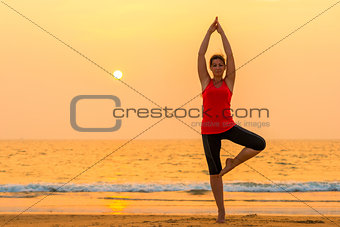 portrait of a girl doing yoga on the beach
