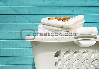 White laundry basket with towels and pins