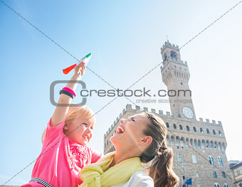 Happy mother and daughter with Italian flag near Palazzo Vecchio