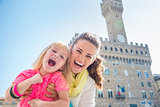 Portrait of cheerful mother and child near Palazzo Vecchio