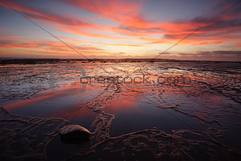 Sunrise over Long Reef at low tide with reflectins
