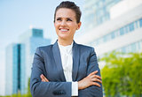 Smiling business woman in office district looking into distance