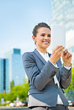 Smiling business woman using tablet PC in modern office district