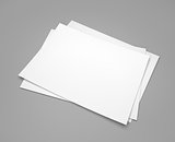 Three white paper sheets on gray