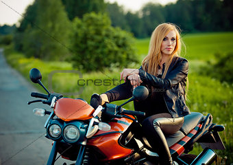 Outdoor fashion portrait of young sexy tan blonde woman posing  red scooter bike at sunshine.