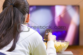 Teenager girl laying down and watching tv