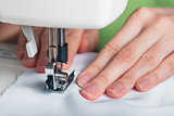 Hands of young girl on sewing machine